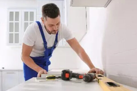 a man is working on countertop