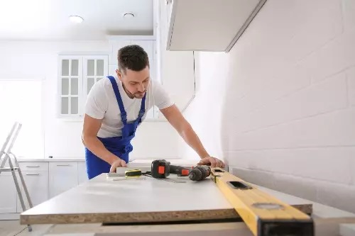 a man is working on countertop