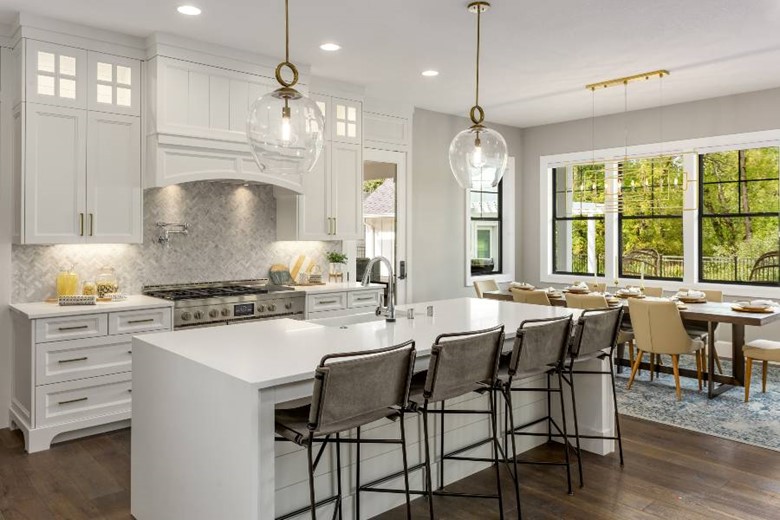 A kitchen with a large island and chairs