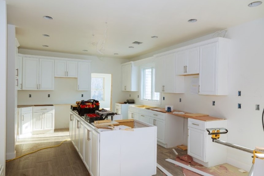 A kitchen with white cabinets and a counter top