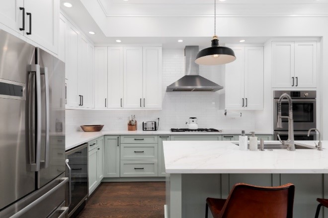 A kitchen with white cabinets and a white island
