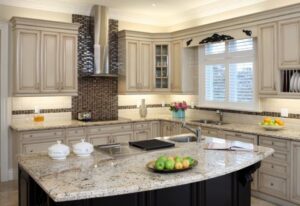 Traditional kitchen with beige cabinets, granite countertops, and stainless steel range hood in Durango, CO