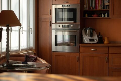 Warm-toned kitchen with wooden cabinets, built-in stainless steel oven, and cozy breakfast nook in Durango, CO